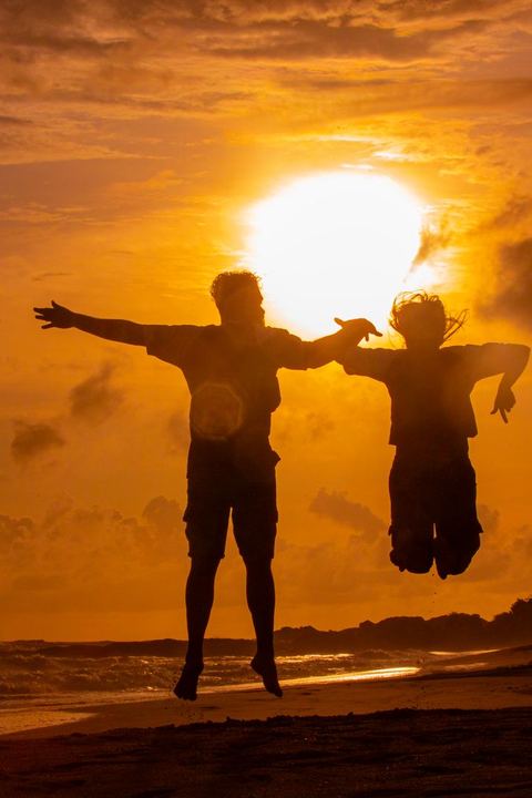 Two friends jumping at sunset on Galle beach